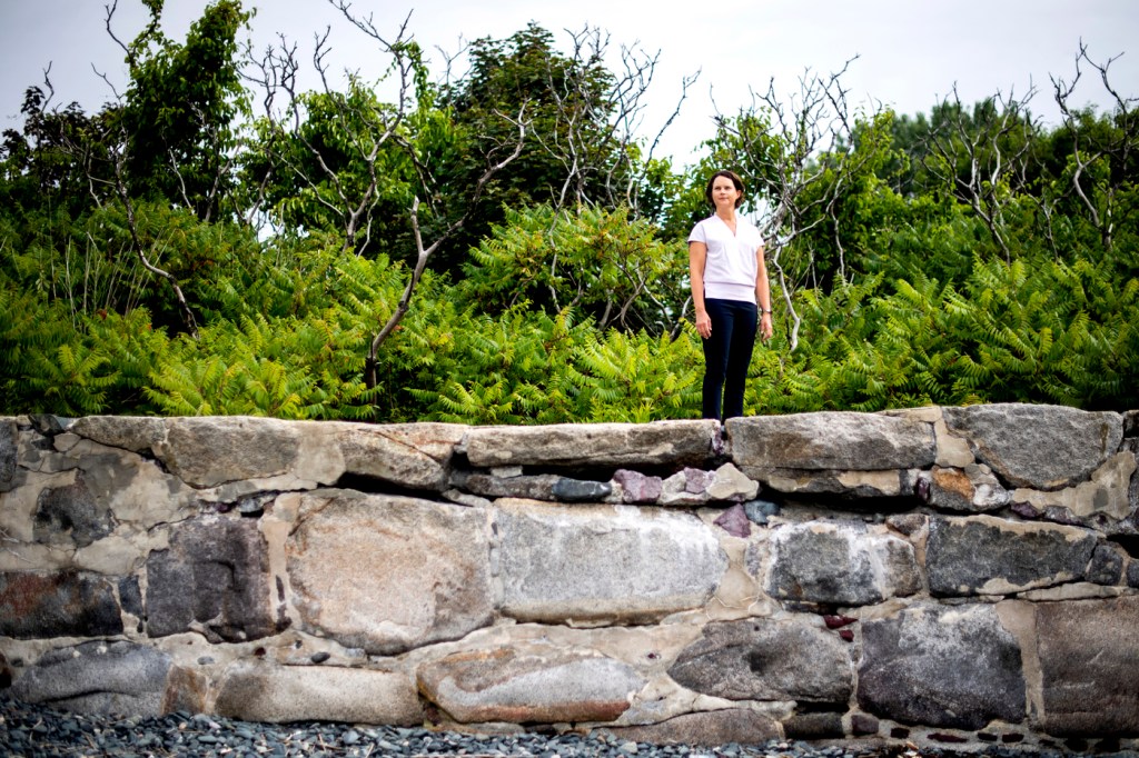Randall Hughes standing outside on a rock wall.