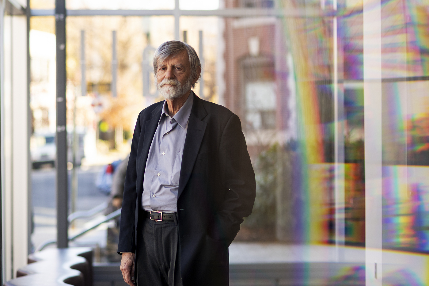 man with grey hair and beard posing for a portrait