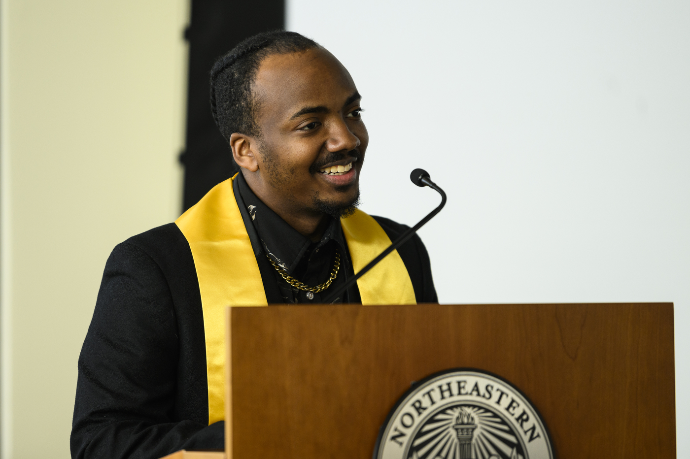 A person stands behind a podium with a microphone