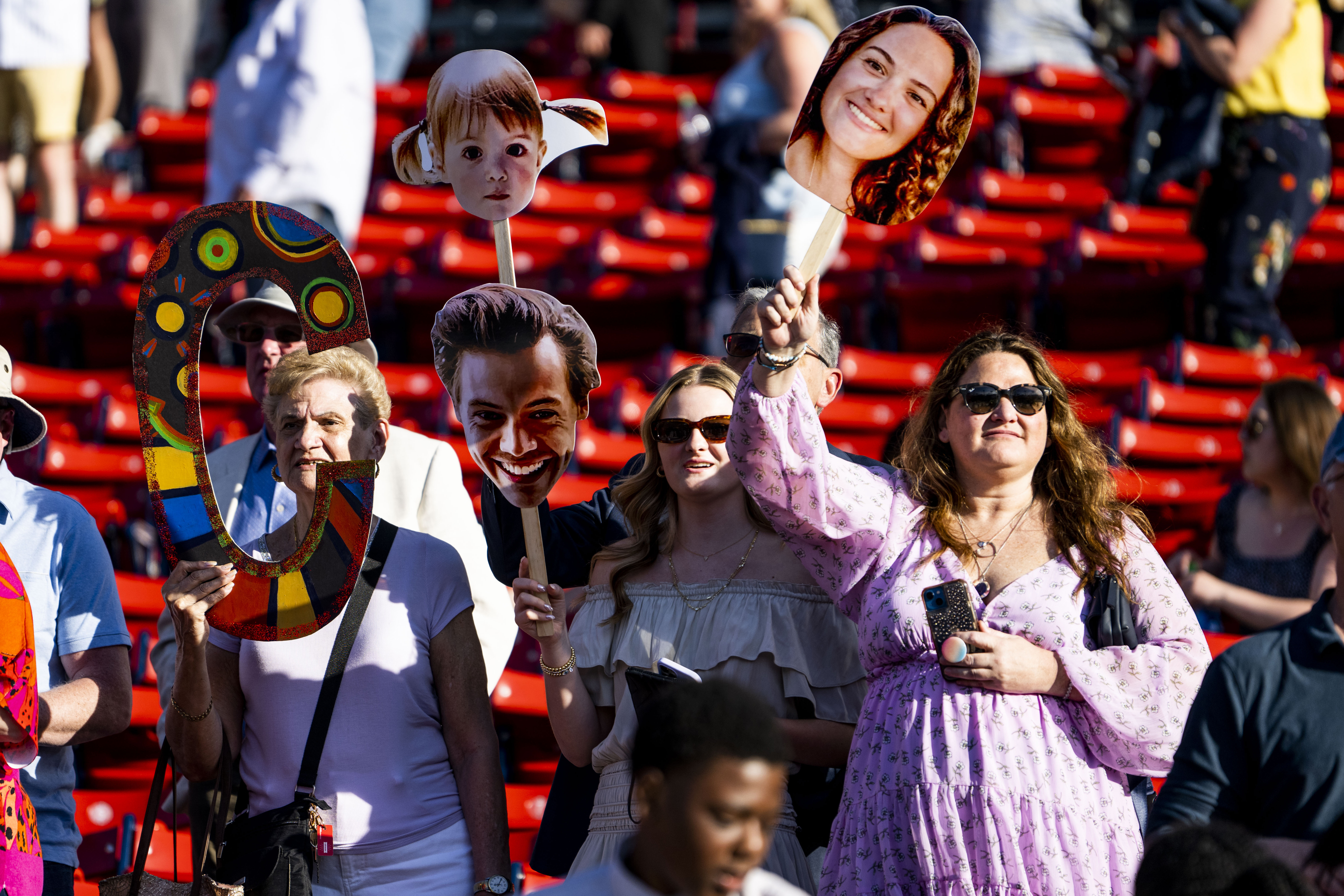 northeastern families waving poster cut outs of graduates heads