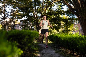 Laura Green, an influencer comedian, runs through a park on a sunny day.