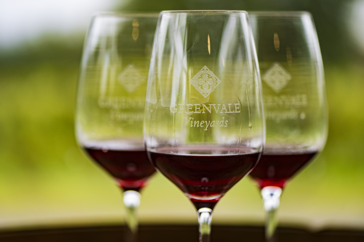 Three wine glasses embossed with Greenvale Vineyards logo.