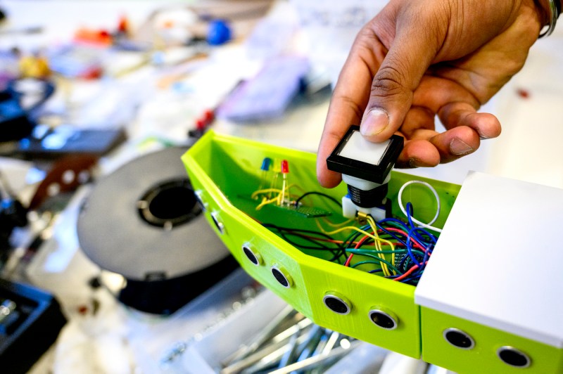 An engineering student working on a wheelchair backup sensor project.