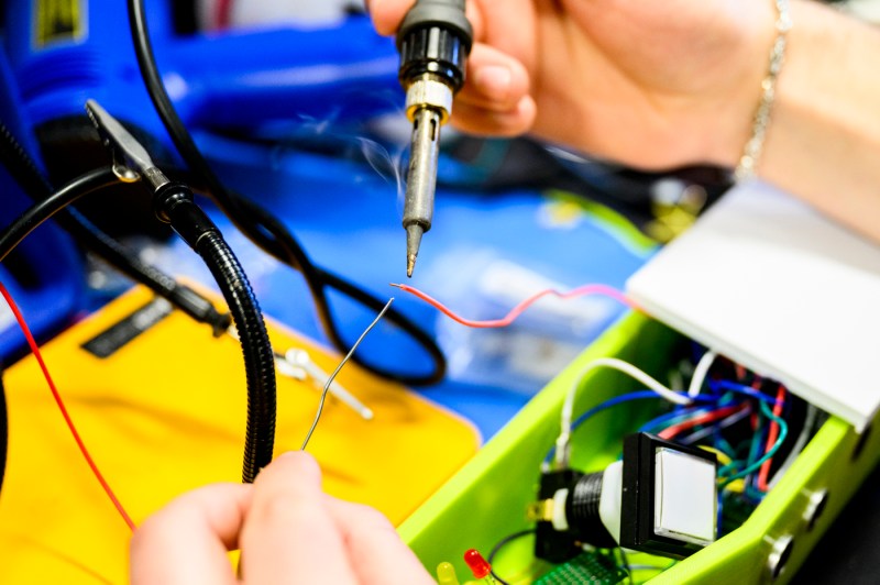 An engineering student working on a wheelchair backup sensor project.
