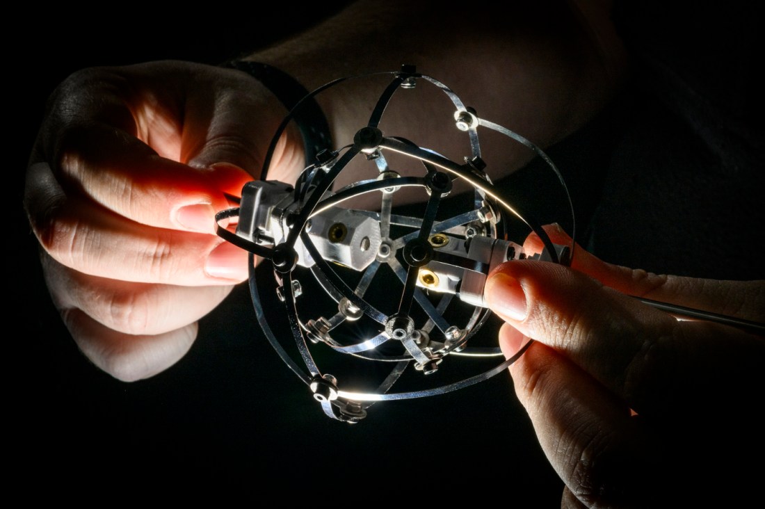 Jeffrey Lipton's hands holding a component of the robot.