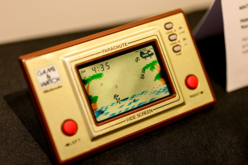 A rectangular gaming device that says 'Parachute Wide Screen on it' with buttons on either side of a screen.