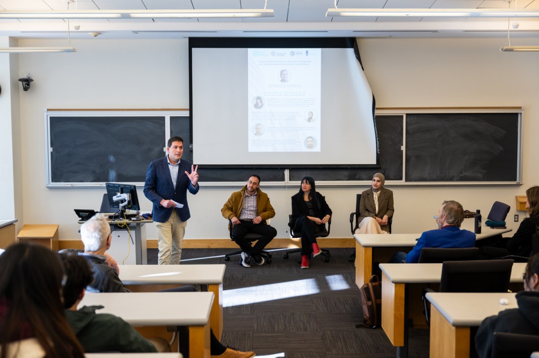 Professor leads a panel discussion with entrepreneurs and alumni during an event.