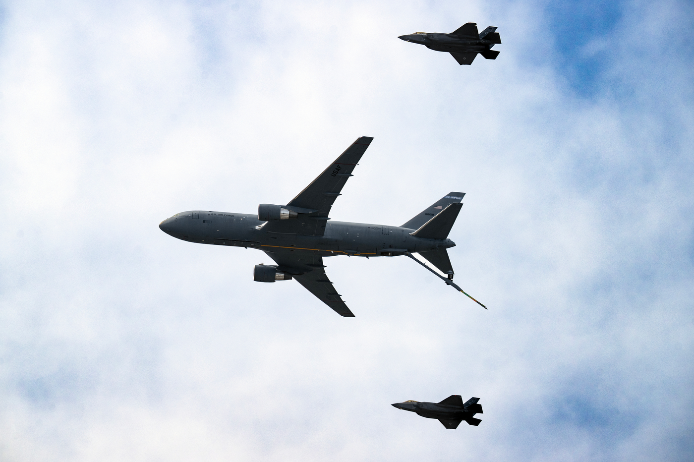 A KC-36 plane flanked by two F-35 jets in the sky.