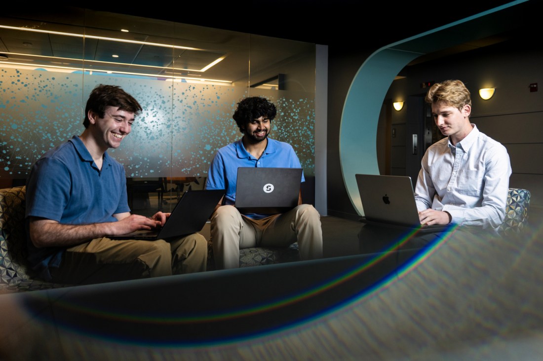 Jonathan Feldman, Dilan Bhat, and Benjamin Wetzell sitting in a circle working on their laptops.