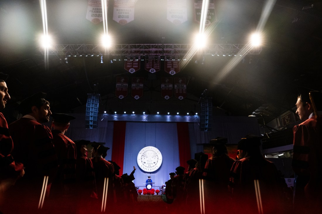 Grads lined up in Matthews arena at the PhD hooding and commencement ceremony.