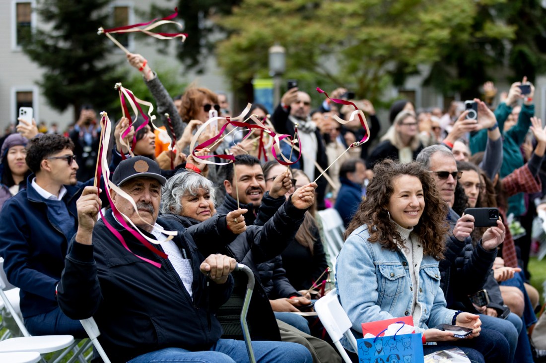 Friends and family members waving streamers at the Oakland commencement.