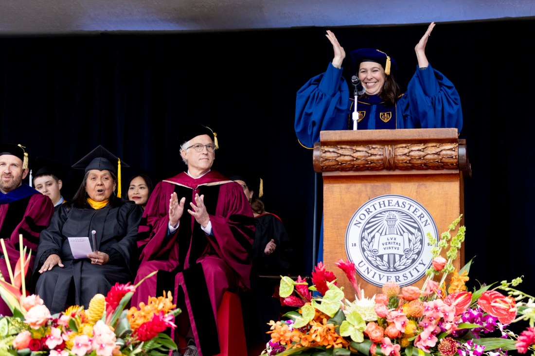 Beth Kochly with her hands in the air at the Oakland commencement.