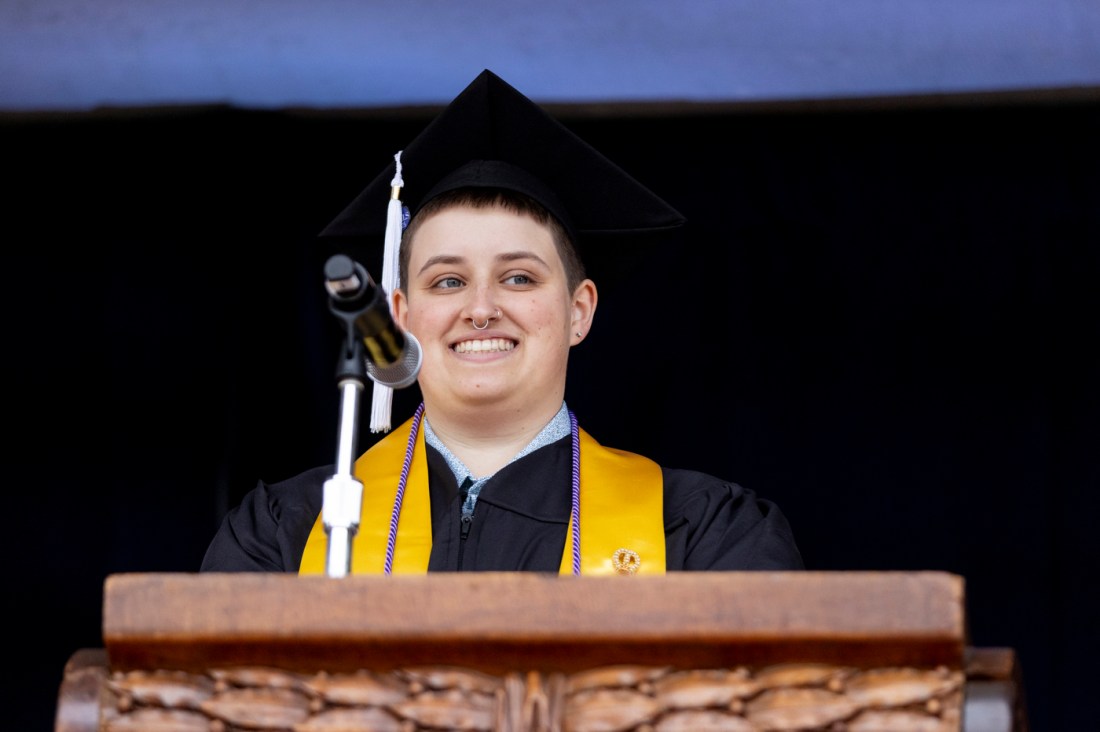 Teddy Johnstone smiling on stage at the Oakland Commencement.