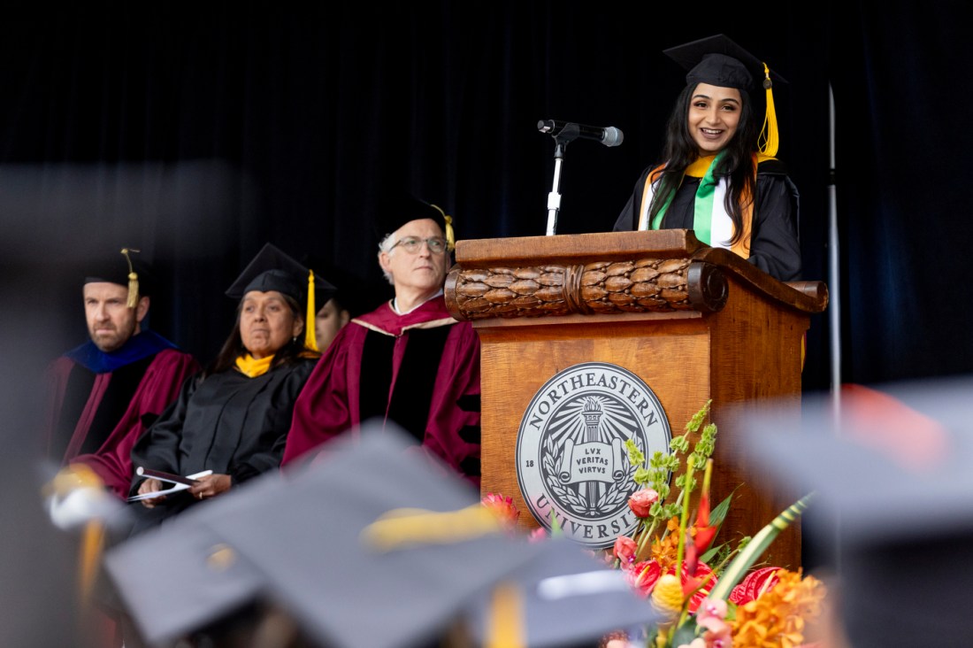 Diya Wadhwani smiling on stage at the Oakland commencement ceremony.