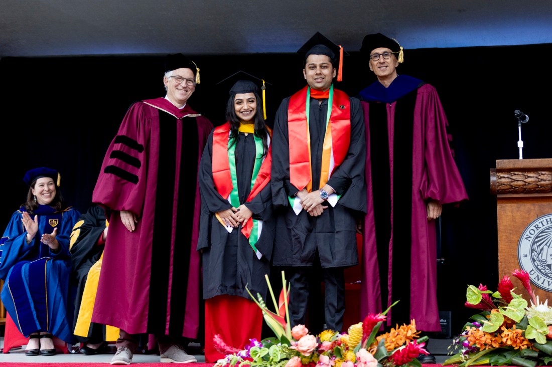 Daniel Sachs and Waleed Meleis pose on stage with Diya Wadhwani and Vikram Dhananjay.
