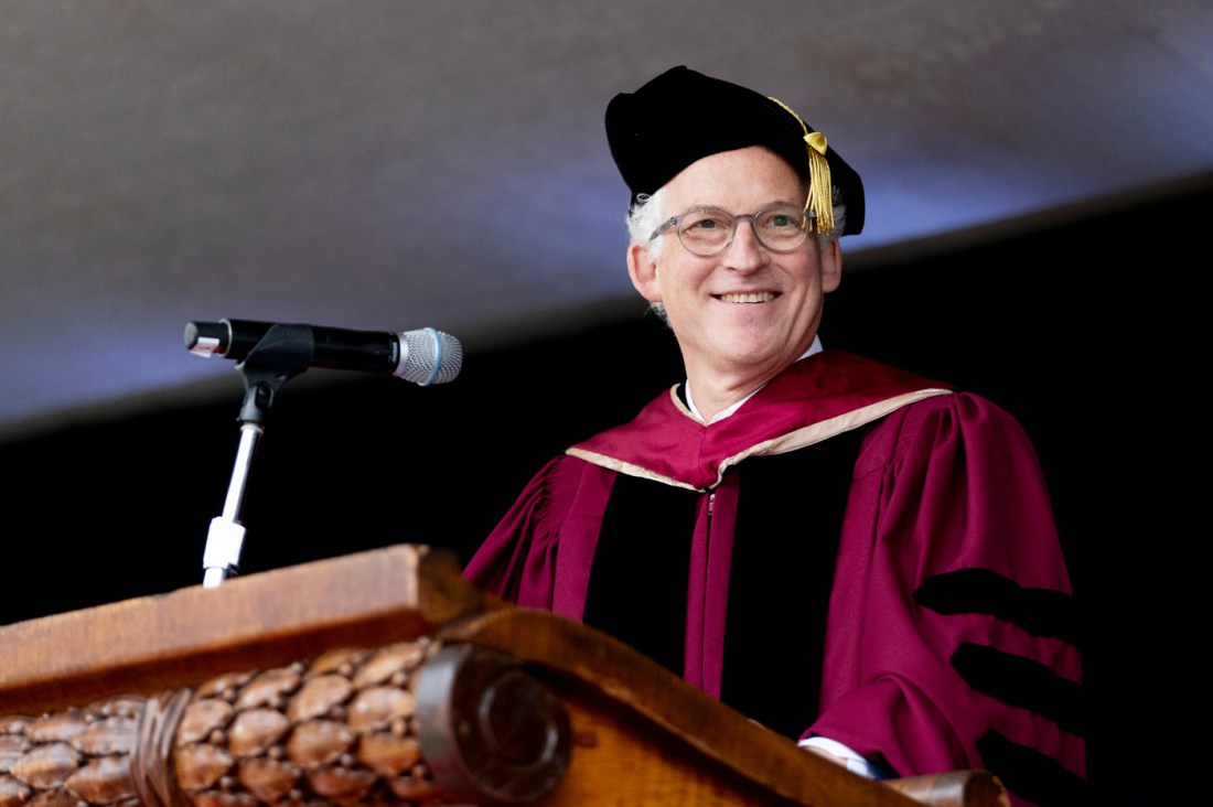 Daniel Sachs smiling on stage at the Oakland commencement ceremony.