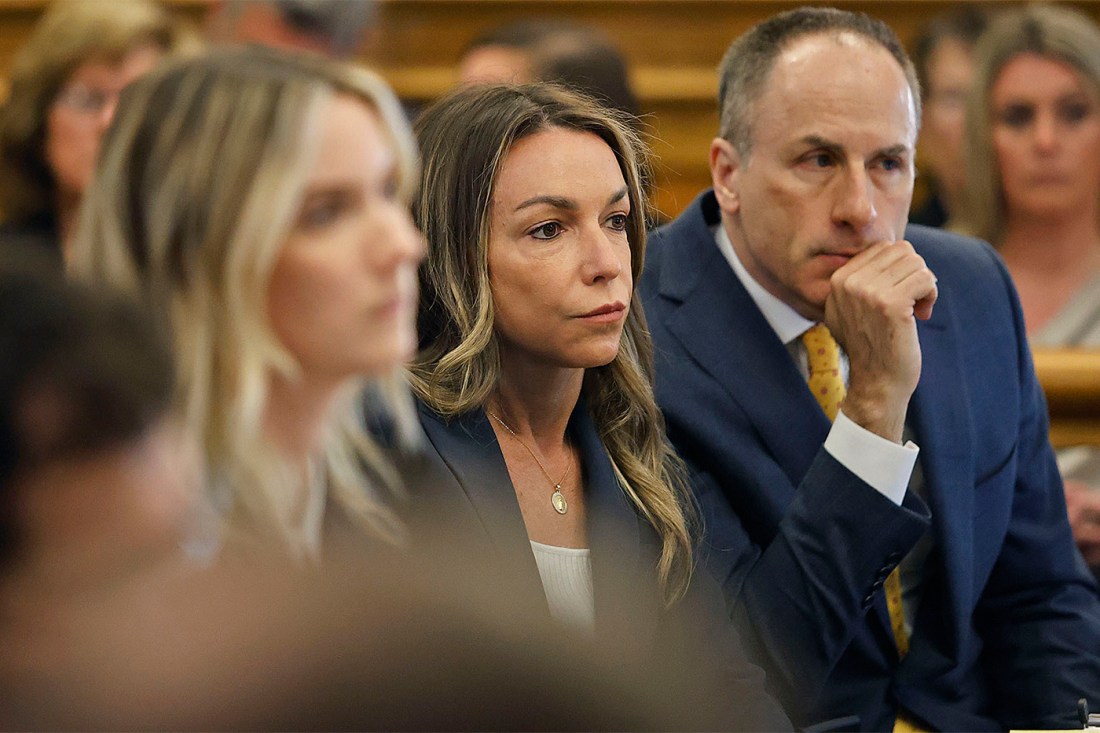 Karen Read sitting in court listening to a person speak out of frame.