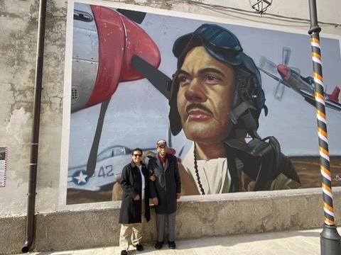 Daniel and Lynn Keel standing in front of a wartime aviation mural in Italy.
