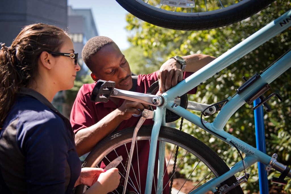 Two people working on a bicycle.