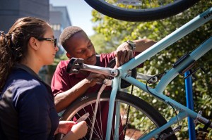Two people working on a bicycle.