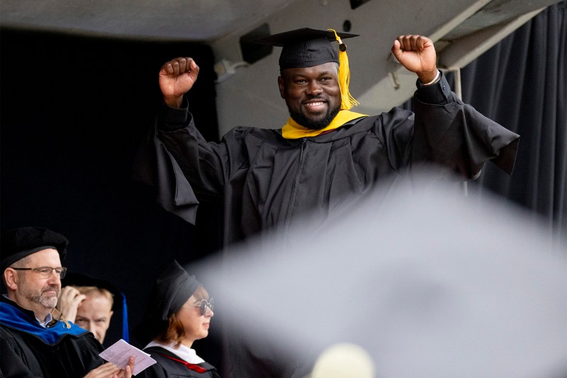 A graduate with a big smile, cheering