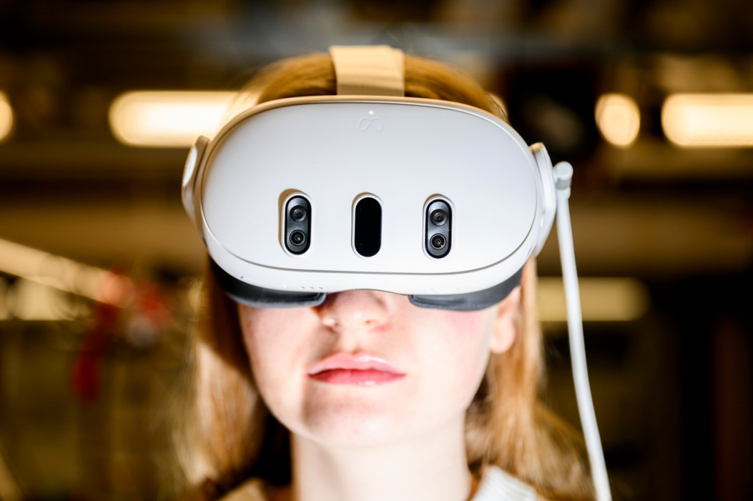 Close-up view of a person wearing a virtual reality headset in a brightly lit space.