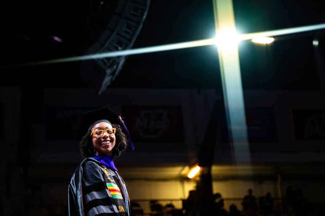 A Northeastern law school graduate smiling on stage at the Commencement ceremony.