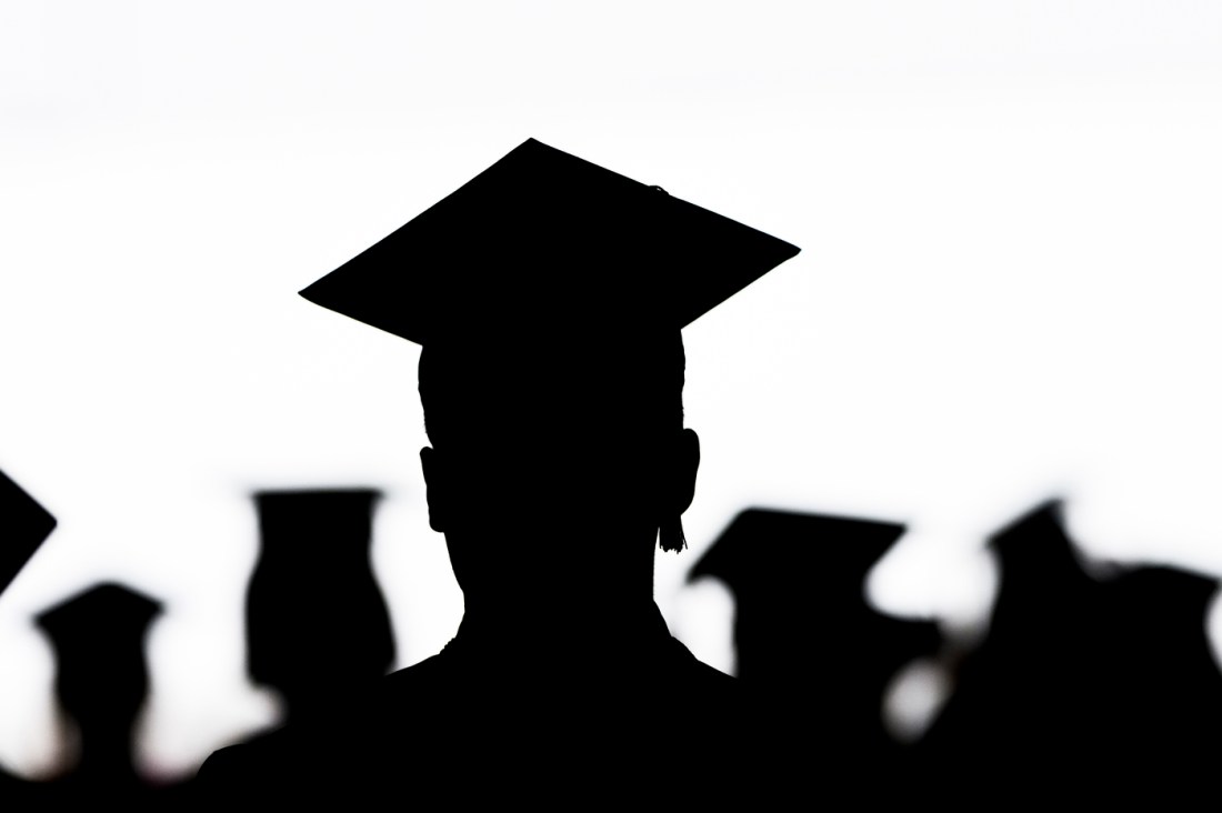 Silhouette of graduates in caps during the Bouve College of Health Sciences commencement ceremony.