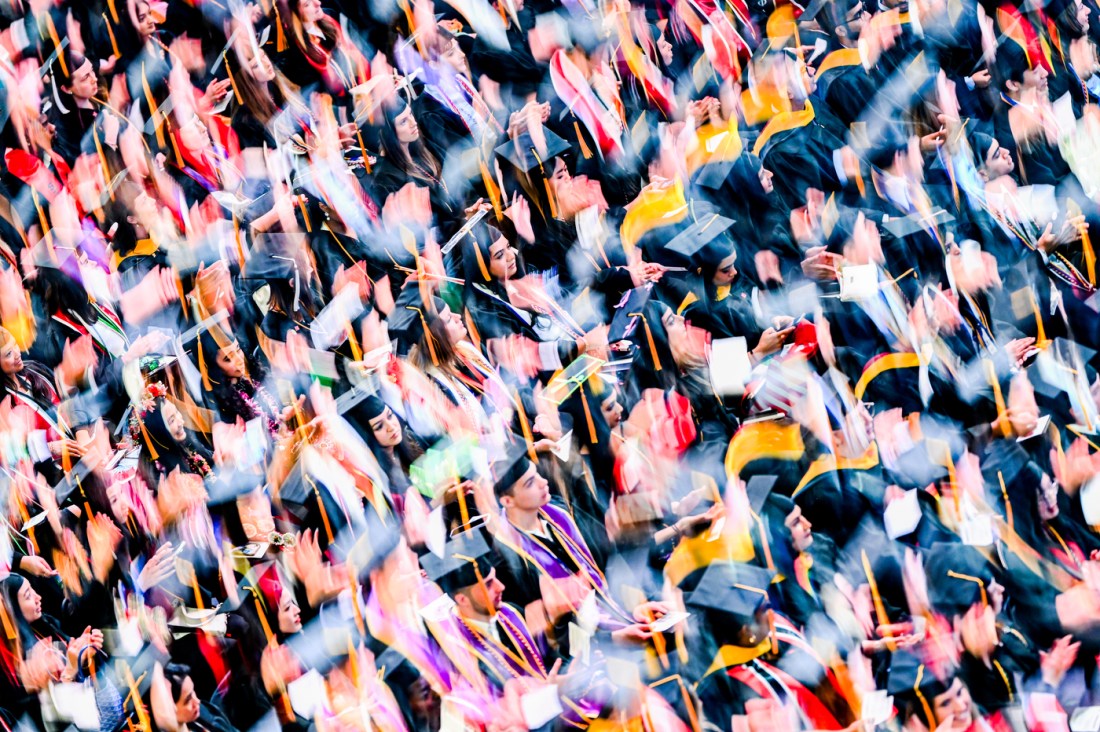 Graduates cheer and wave programs during the Bouve College of Health Sciences commencement ceremony.