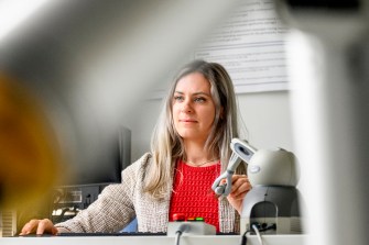 Julia Manczurowsky sitting in a biomechanics lab using motion capture equipment and monitors.