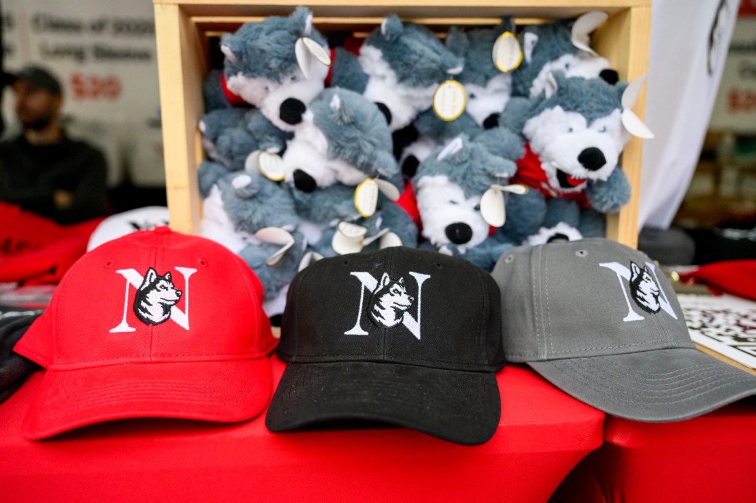 Northeastern branded baseball caps and stuffed Husky toys on sale.