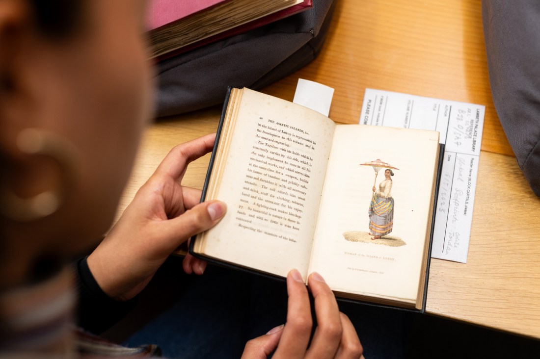 A researcher studies an illustrated book at Lambeth Palace Library.