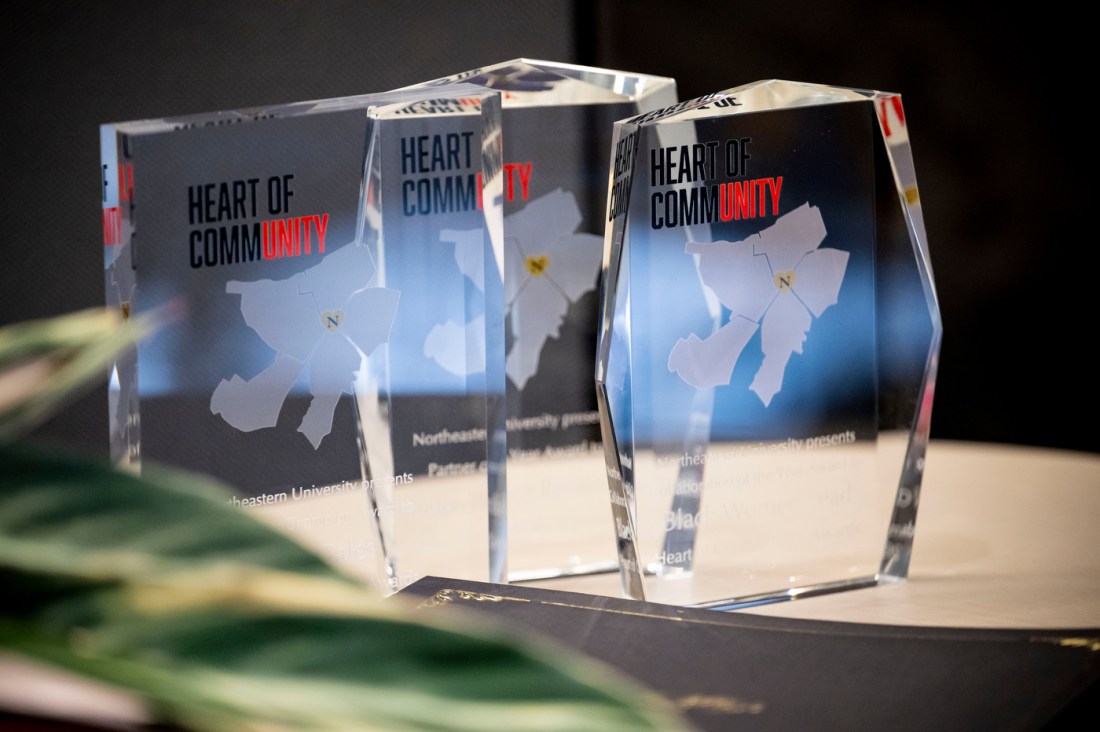 Image 1 (top left): Four crystal award trophies displaying "HEART OF COMMUNITY" text and etched maps, arranged on a table. The awards recognize Partner of the Year, Supervisor of the Year, Collaboration of the Year, and Community Champion in EXP categories.