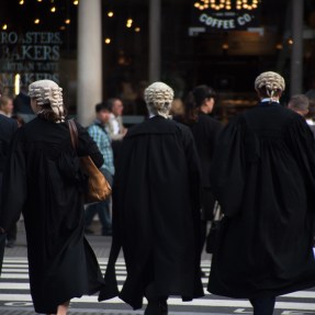 Lawyers walking into the Royal Court of Justice wearing wigs.