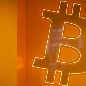 An image of the logo to a cryptocurrency known as Bitocin against an orange backdrop.