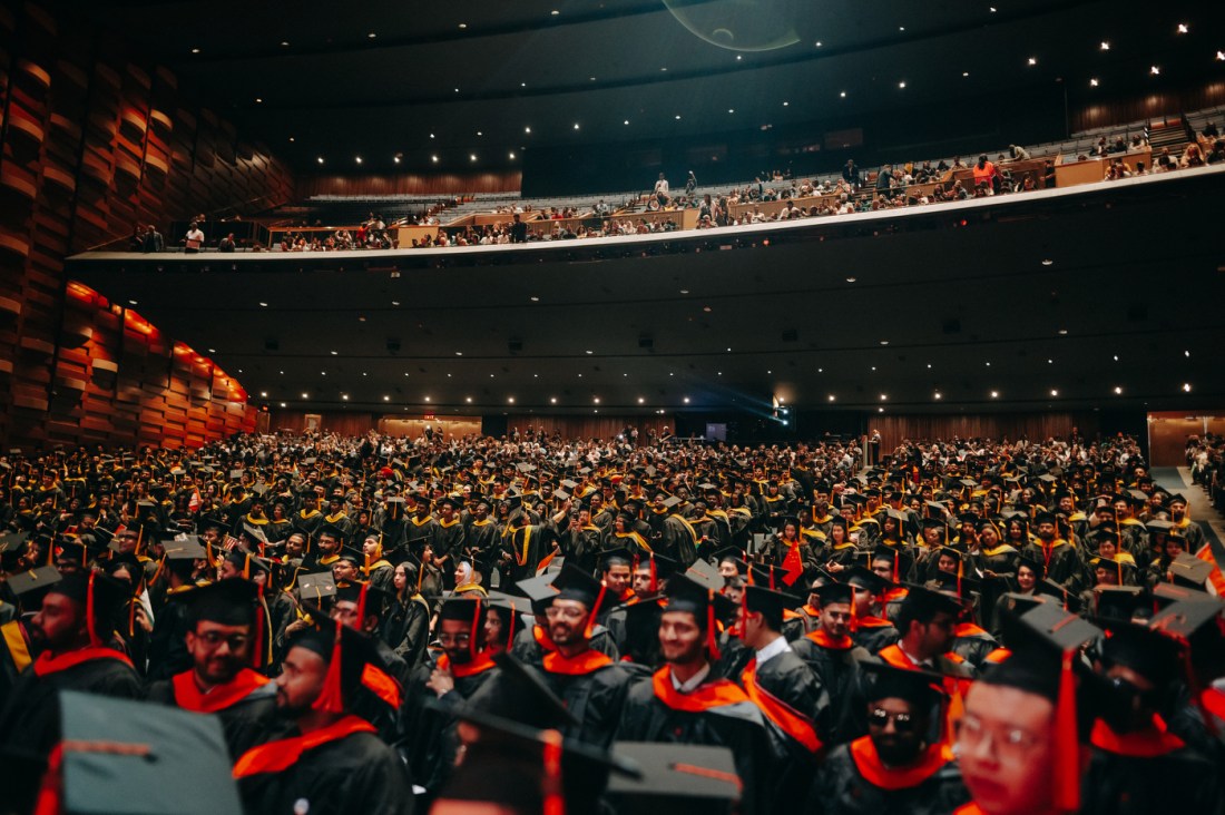 A wide angle shot of graduates and guests filling Meridian Hall for the Toronto campus convocation.