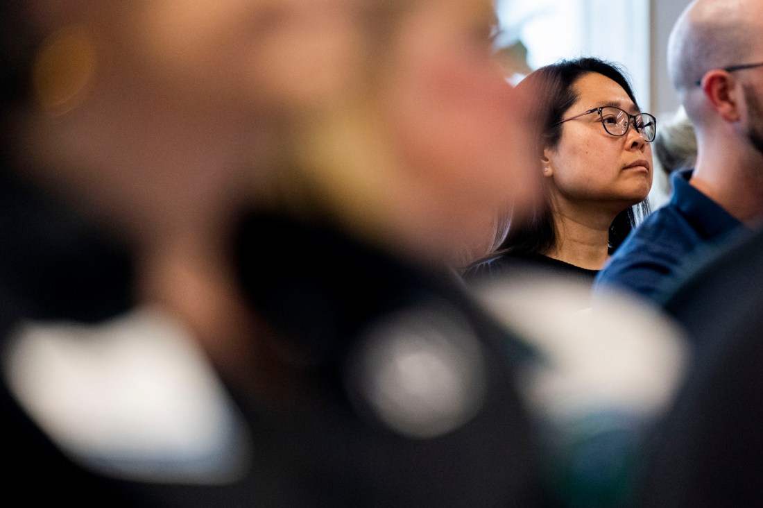 An attendee wearing glasses sitting at the AI in Action Business Summit at the Portland Campus. 