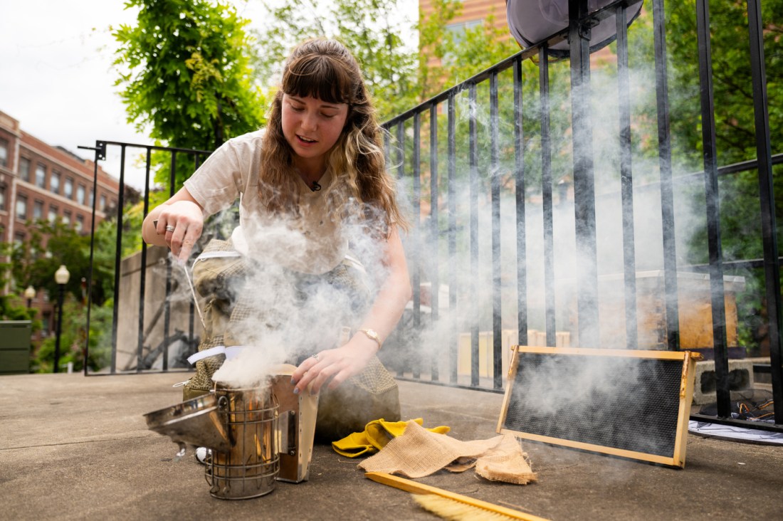 Student Zoleigh Borg prepares a smoker before working with beehives on campus, demonstrating an early step in how to start beekeeping.