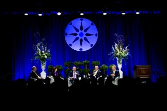 Speakers take part in a panel discussion at an education conference.