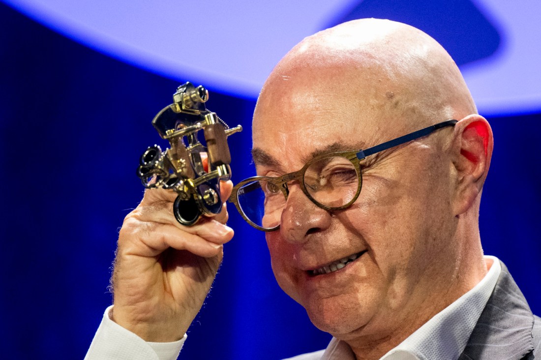  Close-up of a President Aoun holding a microphone during a conference on AI and education.