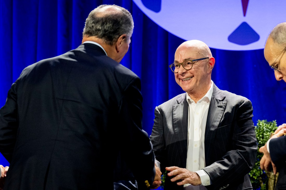 Speakers greet each other before a panel discussion.