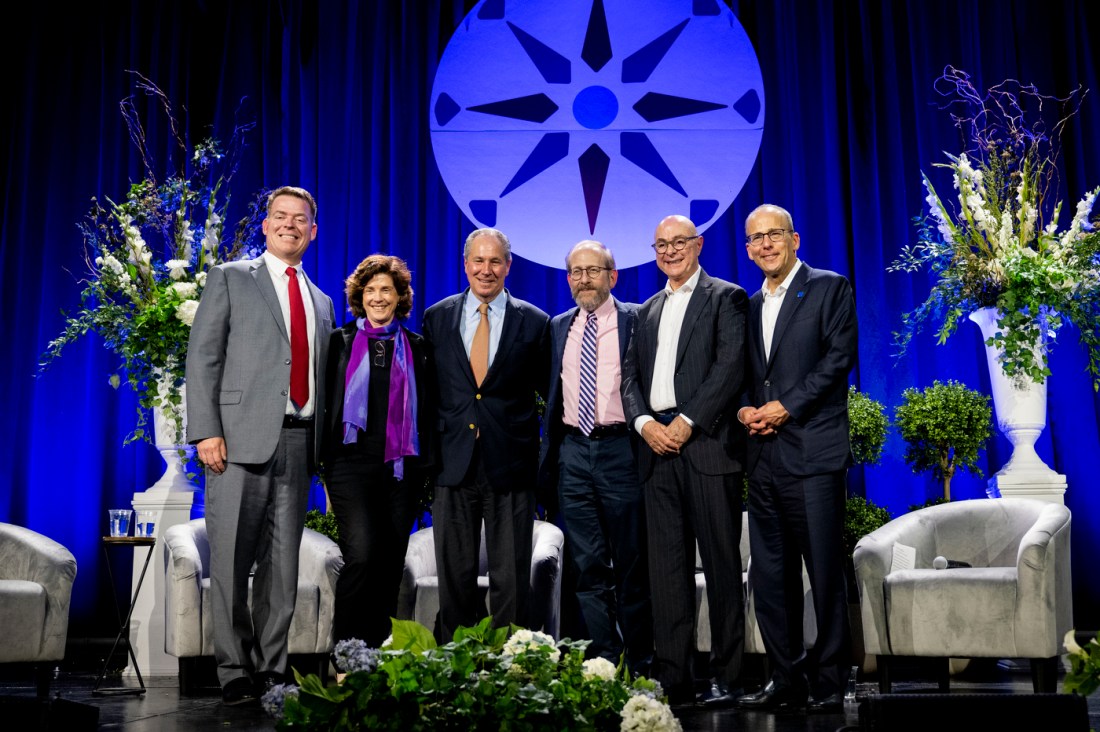 Panelists participate in a discussion on stage during an education conference.