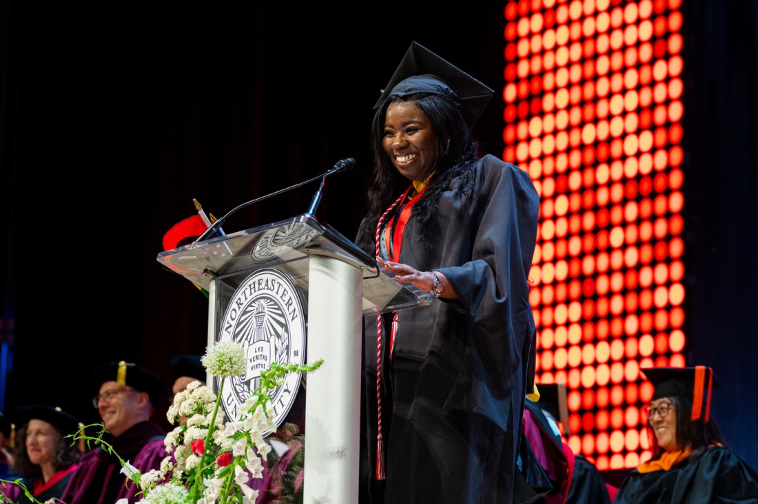 A student speaker smiles while addressing the audience during the Northeastern commencement in Portland.