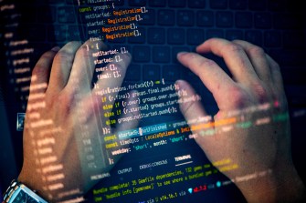 Two hands typing on a laptop. This image is overlaid with another that shows lines of code.