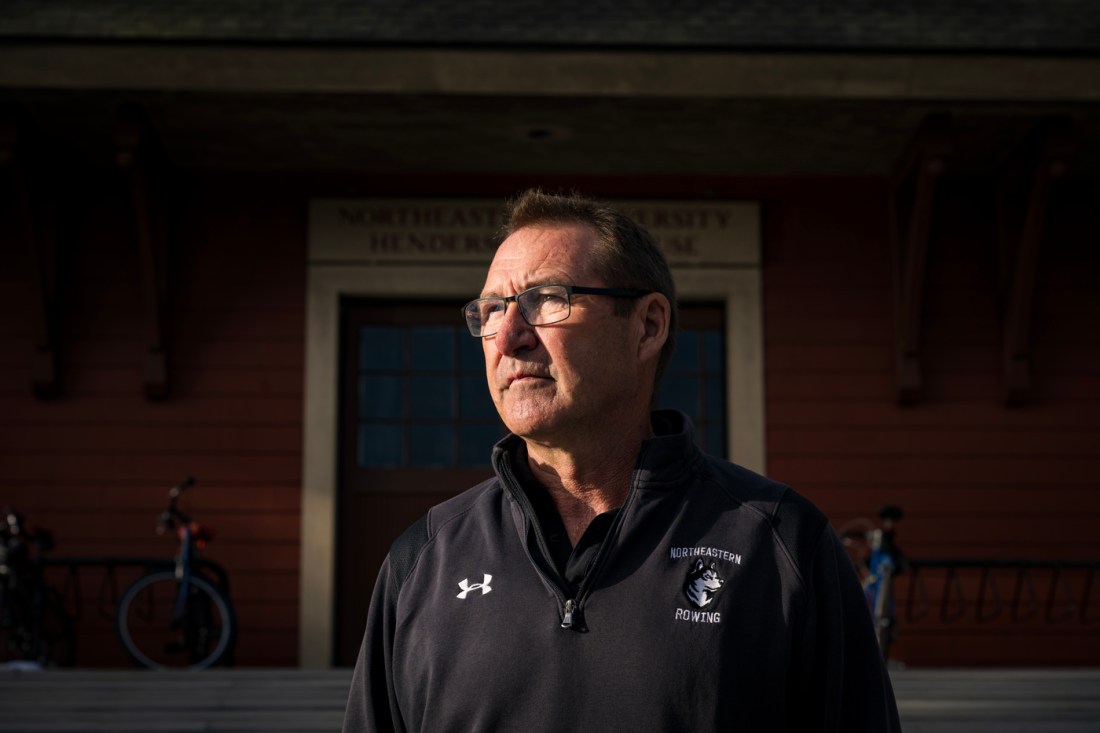 Joe Wilhelm wearing a Underarmor zip up black jacket that says 'Northeastern Rowing' on it with a Husky emblem.