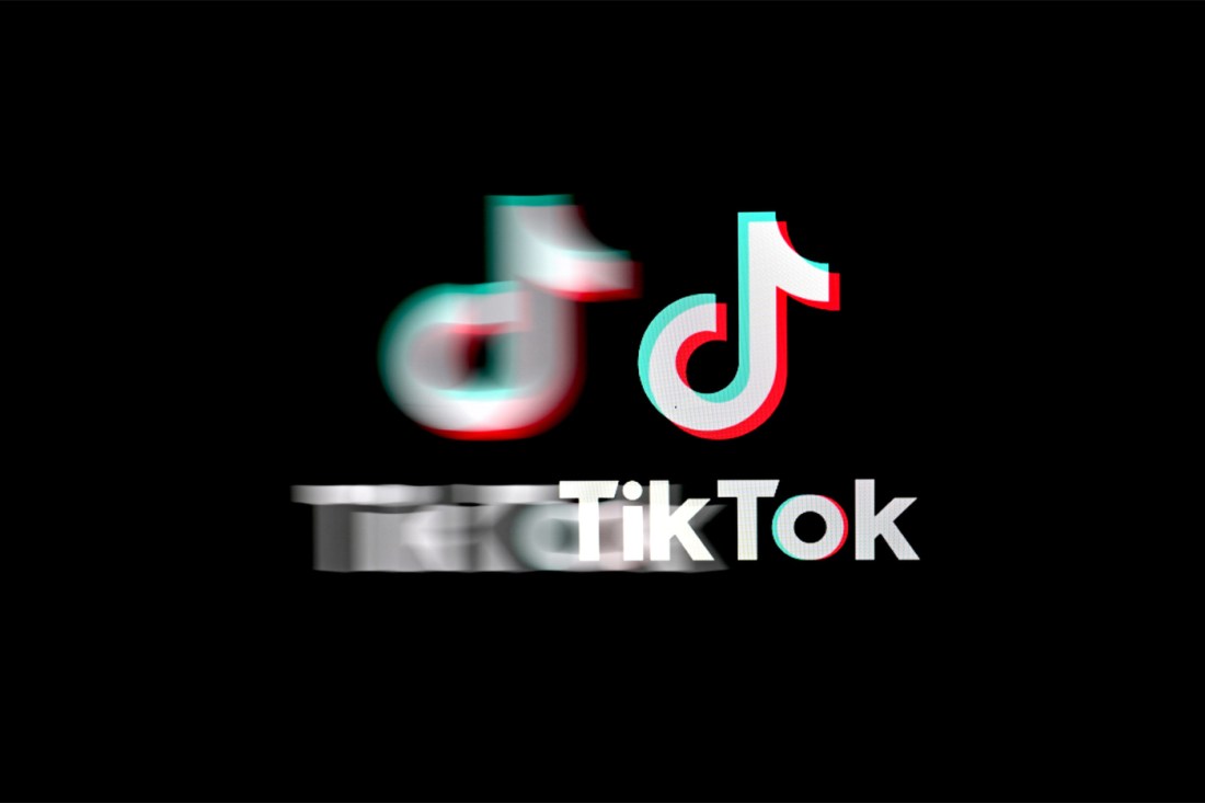 A stylized TikTok logo appears blurry and distorted on a black background.