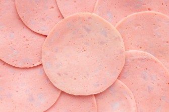 Close-up view of multiple slices of bologna arranged in overlapping layers.