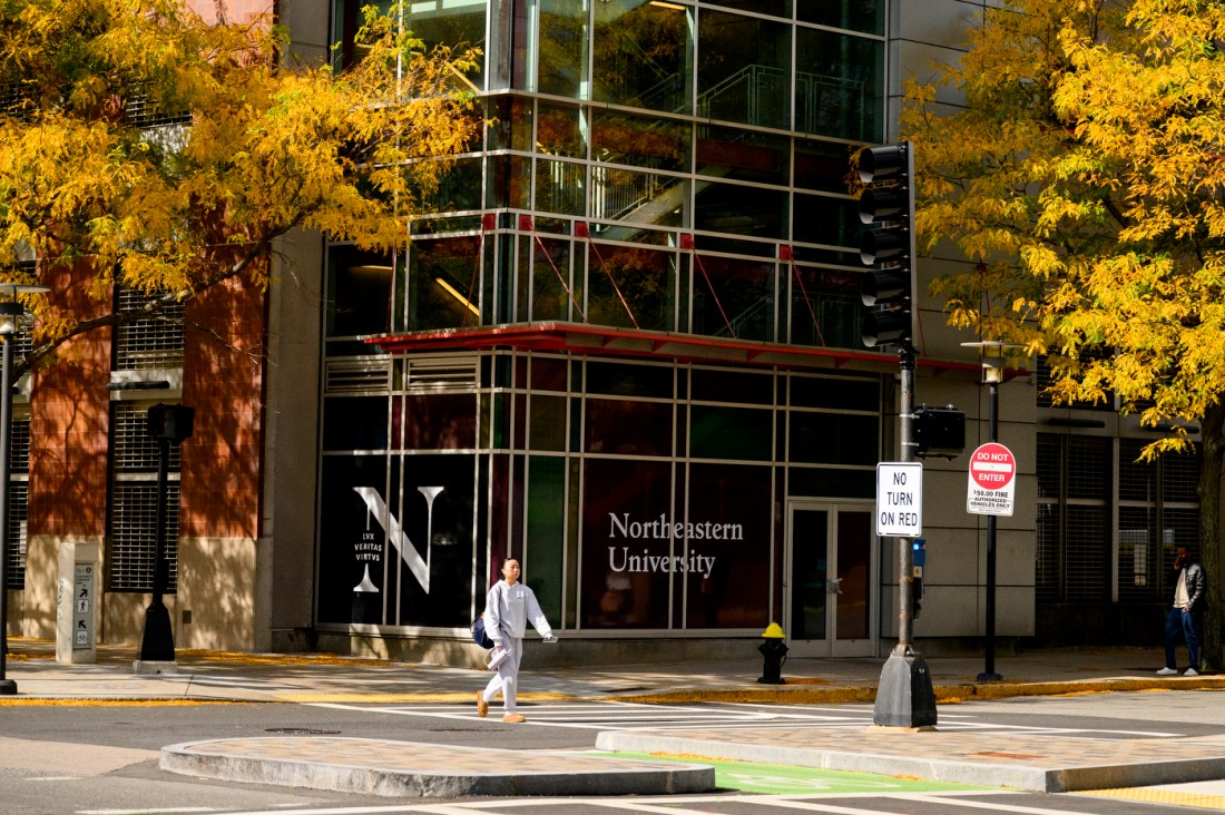 A student walking past a campus building in the fall
