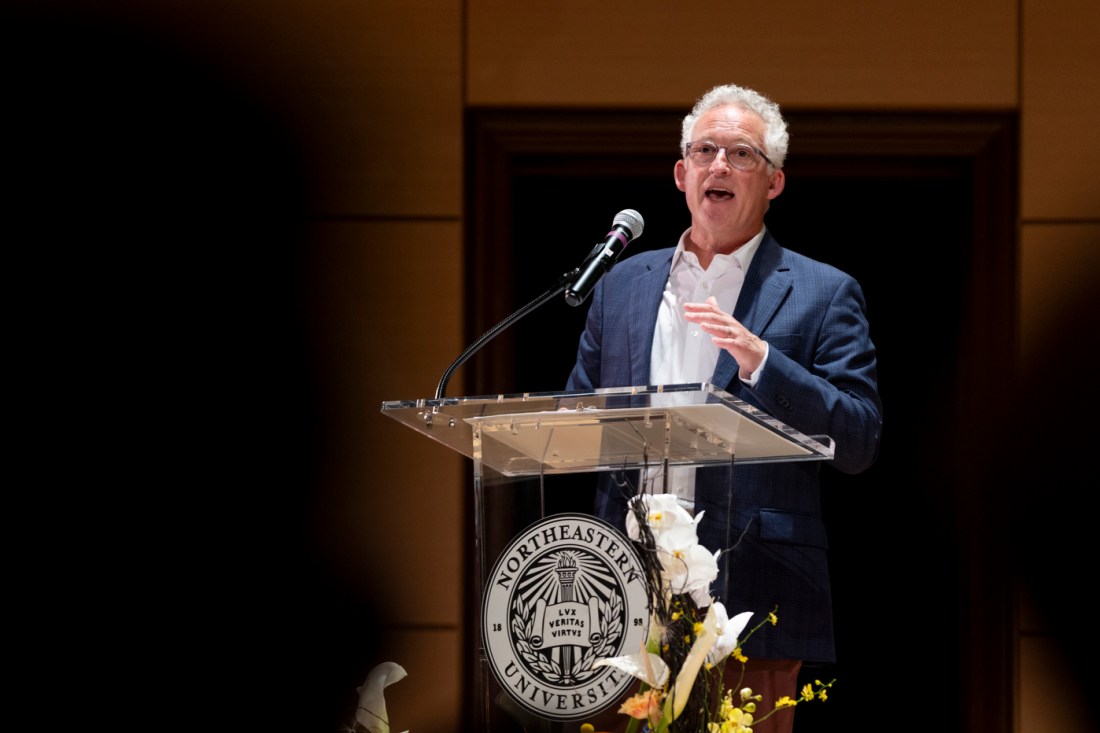 Dean Dan Sachs speaks at a podium bearing Northeastern University’s seal during the Oakland welcome ceremony.