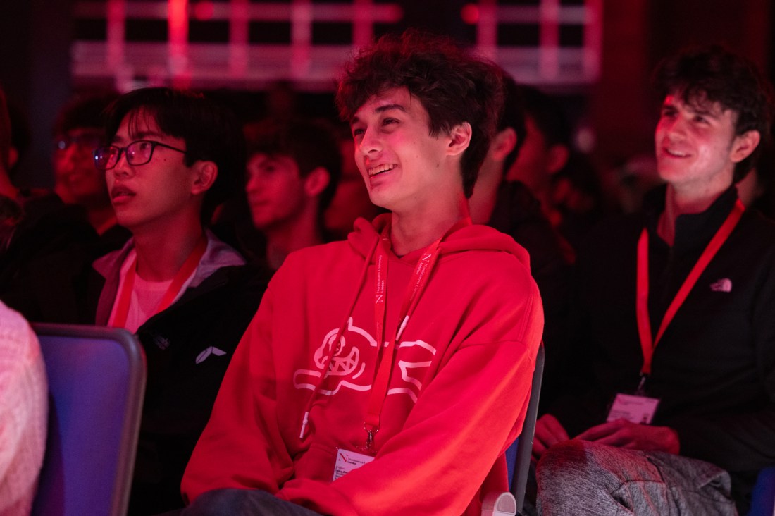A Northeastern student in a red hoodie smiling during the event.